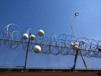 Low angle view of barbed wire against clear sky