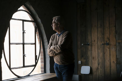 Serious senior businessman looking out of window