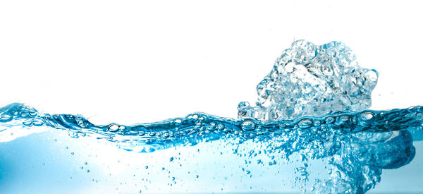 Close-up of splashing water against white background