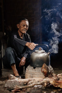 Portrait of old man preparing food