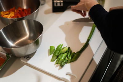 Midsection of person preparing food in kitchen at home