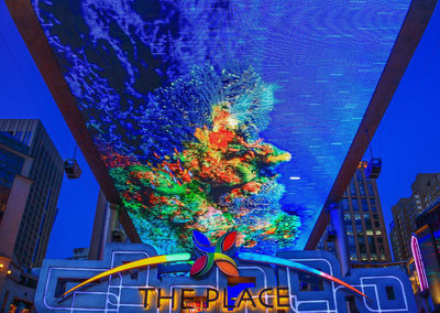 Low angle view of illuminated building against blue sky