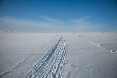 Scenic view of snow covered land against sky