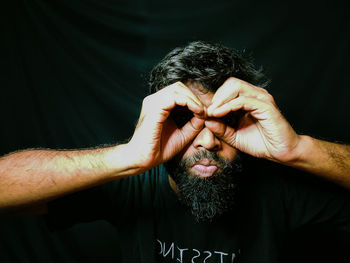 Close-up portrait of man against black background