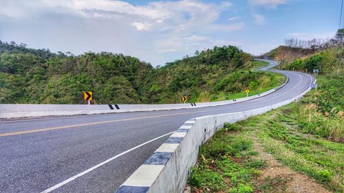 Road by mountain against sky