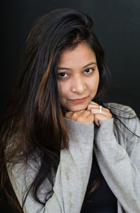 Close-up portrait of a beautiful young woman over black background