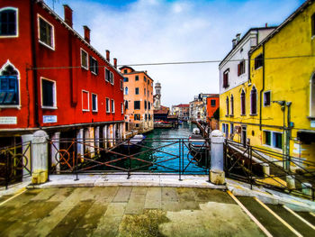 Canal amidst buildings against sky in city