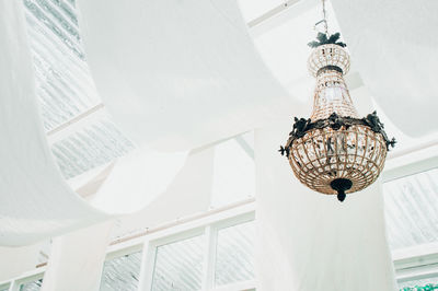 Low angle view of chandelier hanging on ceiling in building