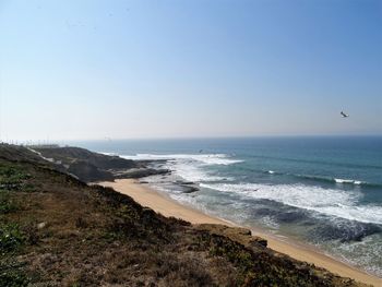 Scenic view of beach against clear blue sky