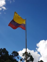 Low angle view of colombian flag against blue sky