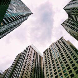 Low angle view of modern building against cloudy sky