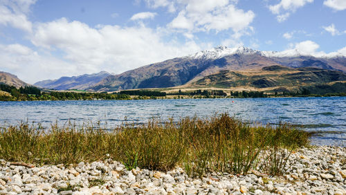 Scenic view of lake by mountains against sky