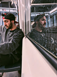 Young man looking through train window