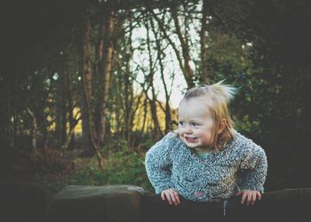 Cute smiling baby girl standing on bench