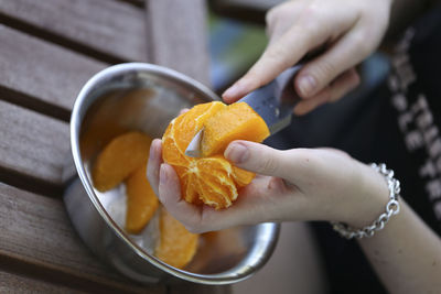 Close-up of hand holding fruits in bowl