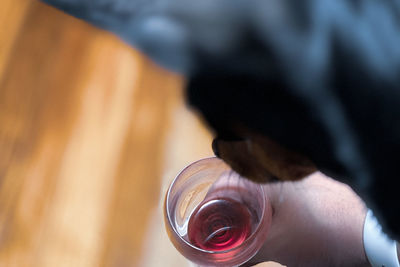 Close-up of hand holding glass of bottle