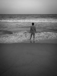 Rear view of boys standing on beach