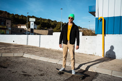 Full length of young man standing against built structure