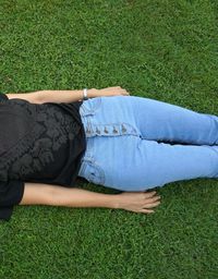 Midsection of woman lying on grass