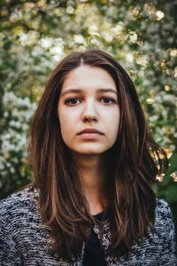 Close-up portrait of young woman against tree