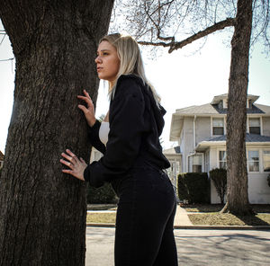 Full length of woman standing on tree trunk