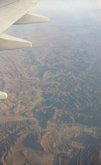 Aerial view of airplane wing over landscape