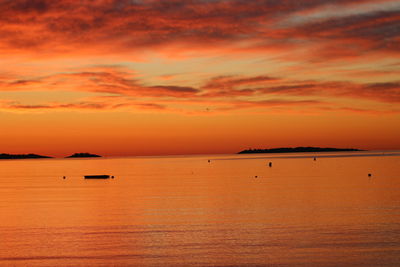 Scenic view of sea against romantic sky at sunset