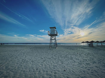 Lifeguard hut on beach against sky