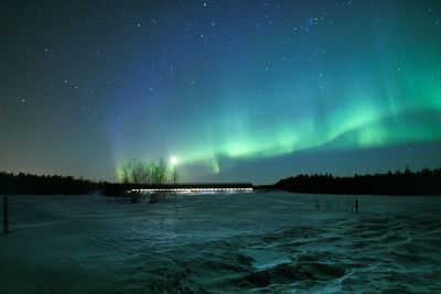 Scenic view of countryside against sky at night during winter