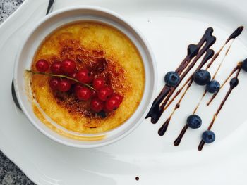 Close-up of creme brulee with berries served in bowl in plate