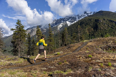 Man amidst plants and mountains against sky