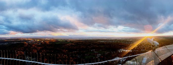 Aerial view of illuminated city against dramatic sky