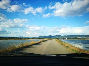 Road against sky seen through car windshield