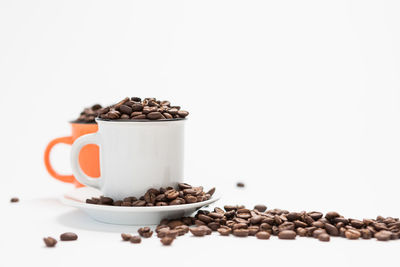 Coffee beans on table against white background