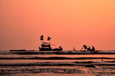 Silhouette ship on sea against clear sky during sunset