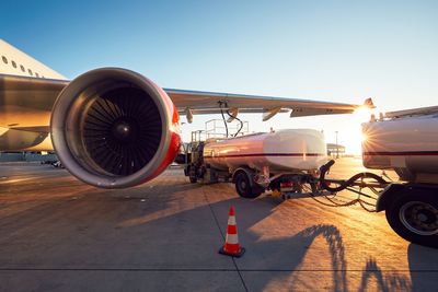 Airplane on airport runway against sky