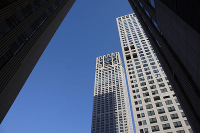 Low angle view of modern buildings against clear blue sky