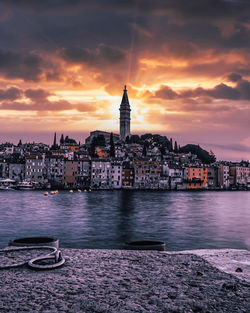 View of buildings at waterfront during sunset