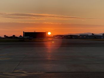 View of airport runway against sky during sunset