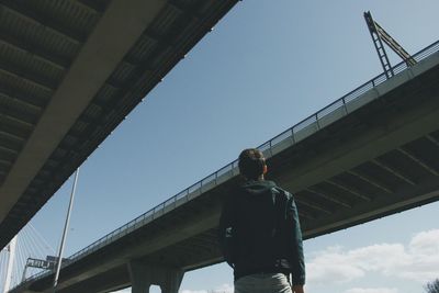 Low angle view of woman standing on bridge