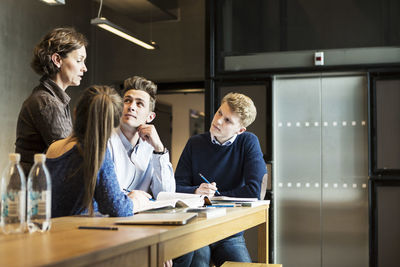 Professor guiding students in classroom