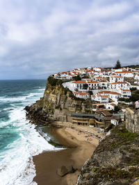 Buildings by sea against sky in city