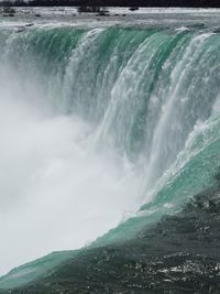 Scenic view of sea against waterfall