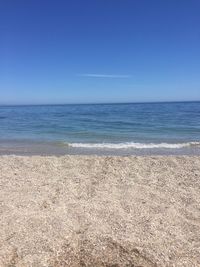 Scenic view of beach against clear blue sky