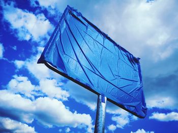 Low angle view of flag against blue sky