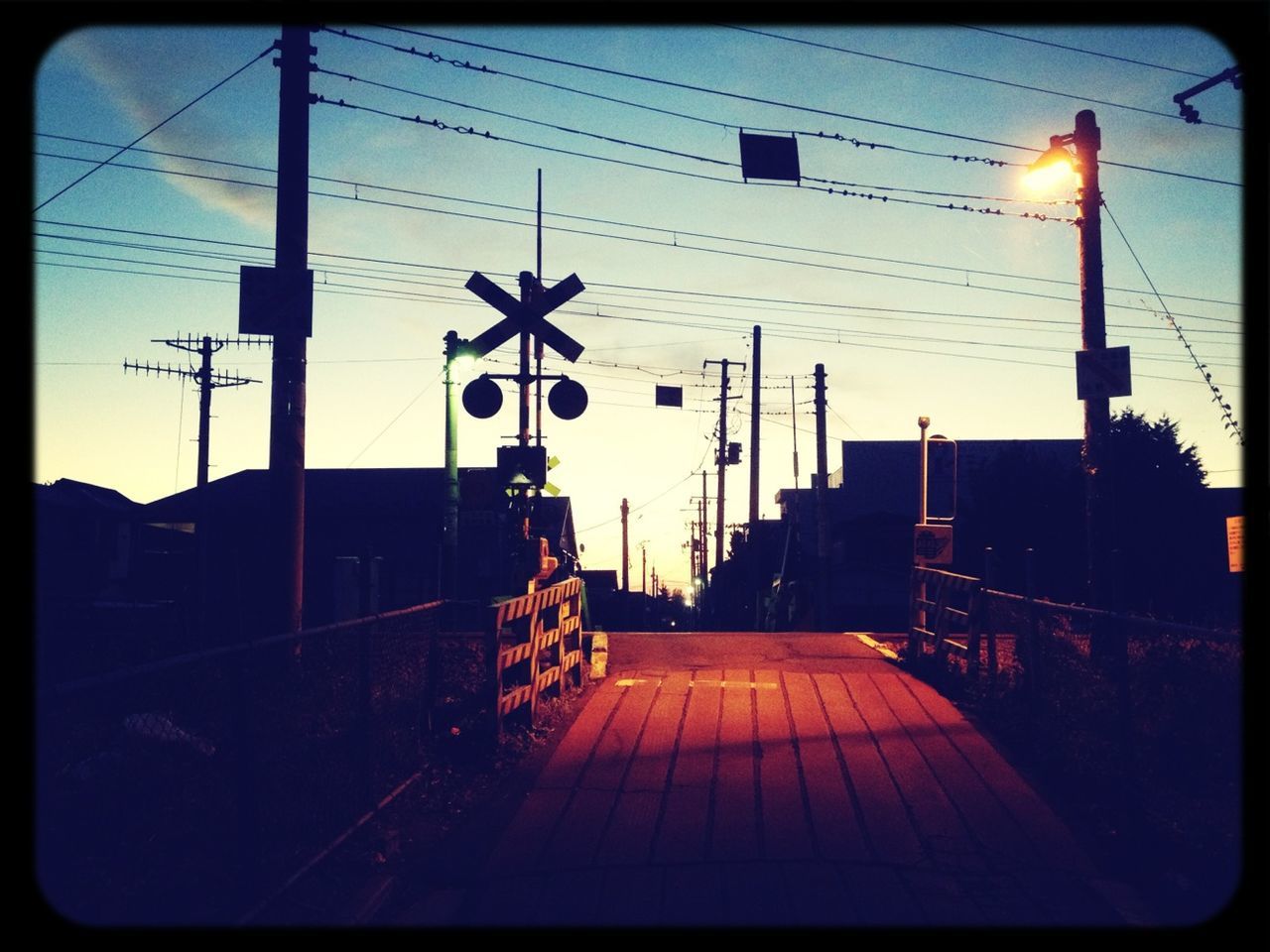 transfer print, street light, architecture, built structure, the way forward, sky, auto post production filter, transportation, lighting equipment, building exterior, railing, connection, diminishing perspective, illuminated, sunlight, outdoors, dusk, no people, empty, pole