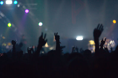 Silhouette people enjoying music concert at night