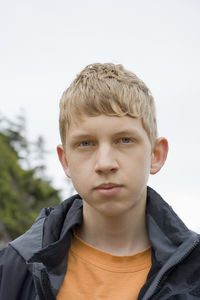 Close-up portrait of boy against sky