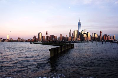 Urban skylines at waterfront against sky