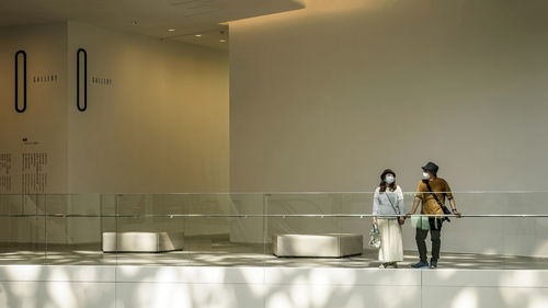 Rear view of couple standing against building